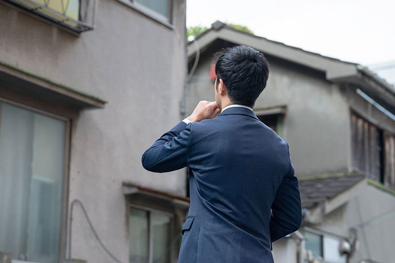 家を見る営業マン